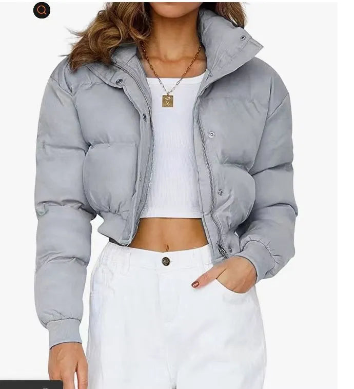 A woman's loose-fitting blue polyester casual jacket with long sleeves on a hanger.