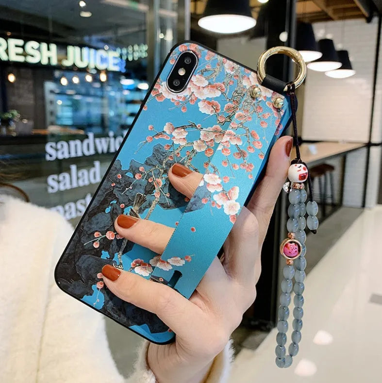 Rose flower design wrist strap case for iPhone on a table