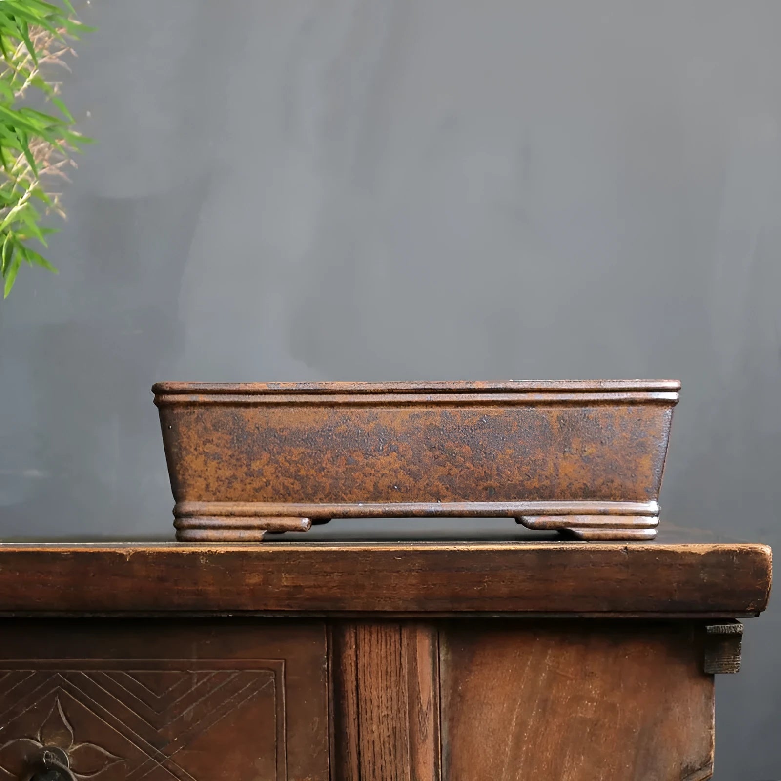 Rectangular purple sand bonsai pot with shallow basin, shown empty on a wooden surface.