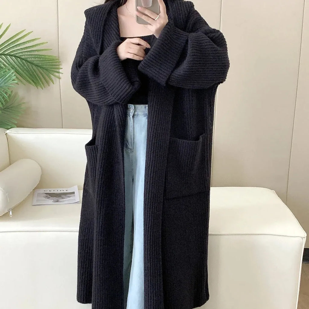 Women's loose grey hooded cardigan coat with raglan sleeves on a hanger.