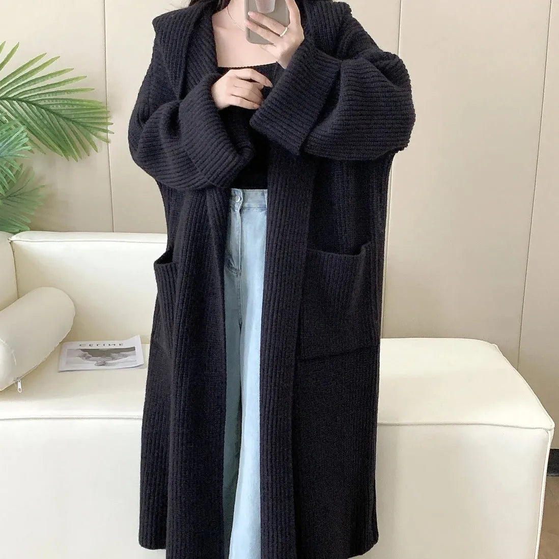 Women's loose grey hooded cardigan coat with raglan sleeves on a hanger.