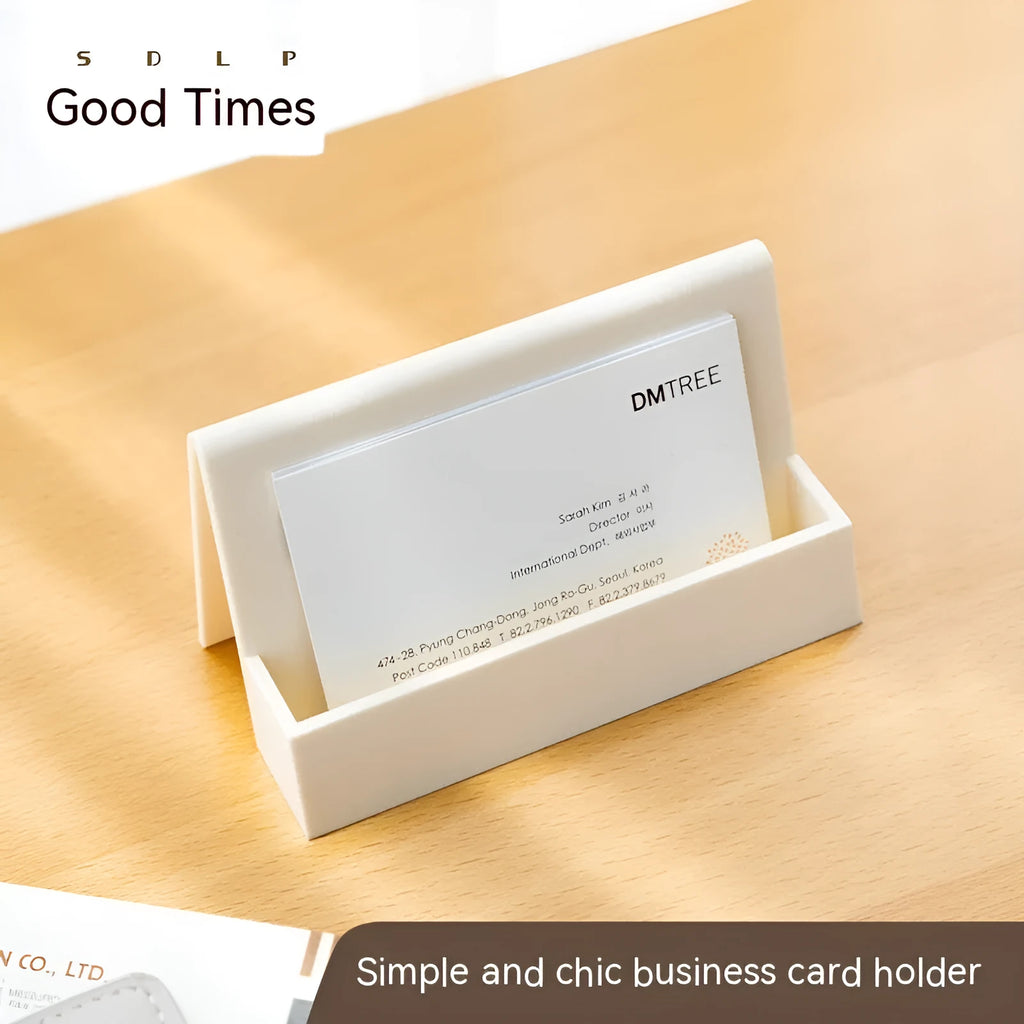 Creative PS geometric business card stand in brown, holding 20 cards upright on a desk.