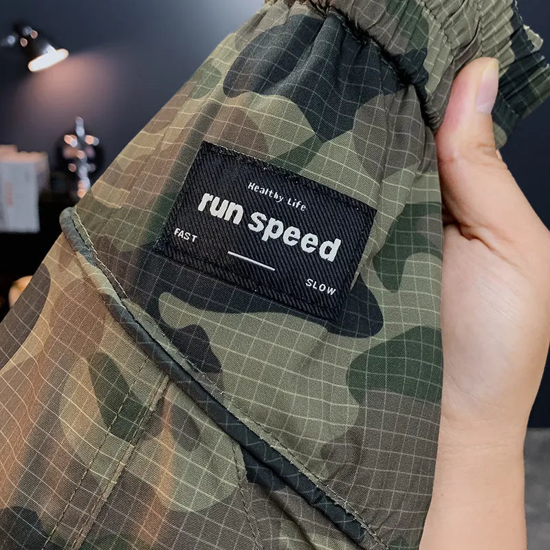 Man wearing olive camouflage cargo shorts with a loose fit and cargo pockets.