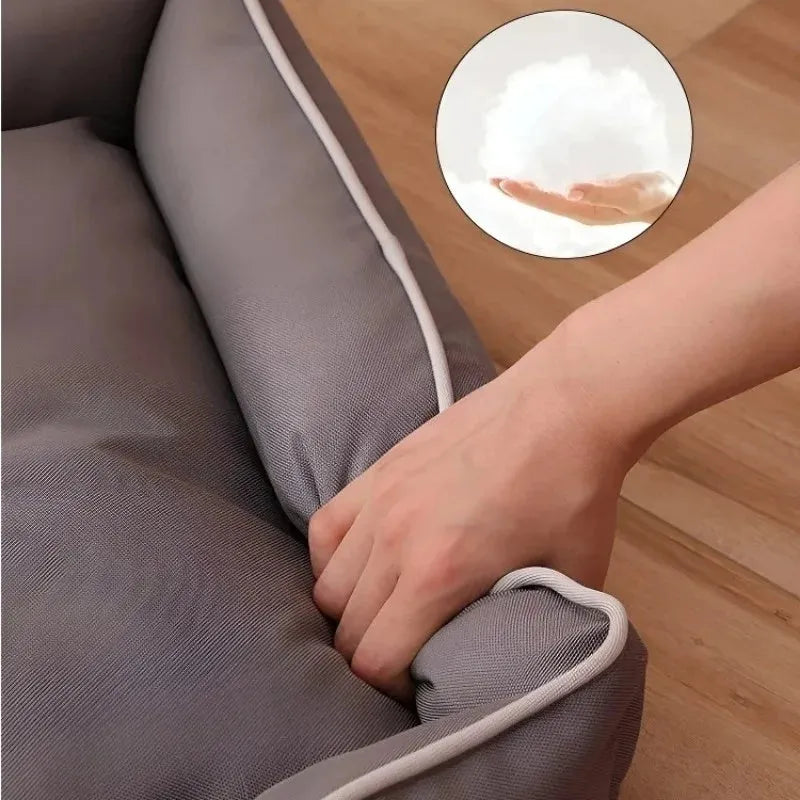 Grey waterproof dog sofa bed with raised edges on wooden floor