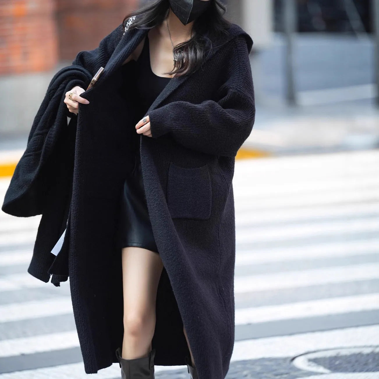 Long grey knitted cardigan with a hood and trench coat style, shown unbuttoned.
