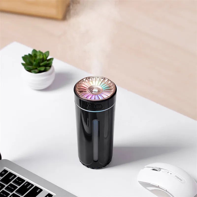 Black portable USB rechargeable humidifier with colourful lights on a car cup holder.