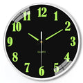 Modern 8 inch circular wall clock with luminous numerals on a white wall
