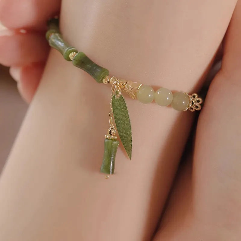 Chinese style glass bracelet with bamboo leaf design on wrist.