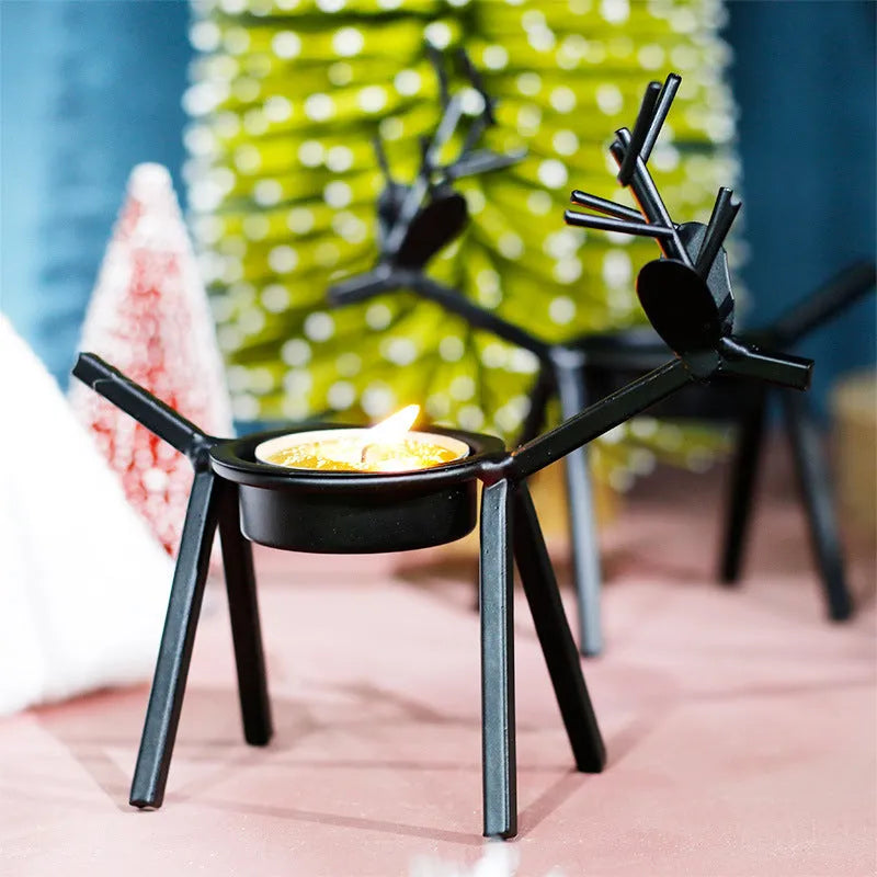 Black iron Christmas candlestick holder with decorative elk bracket design.