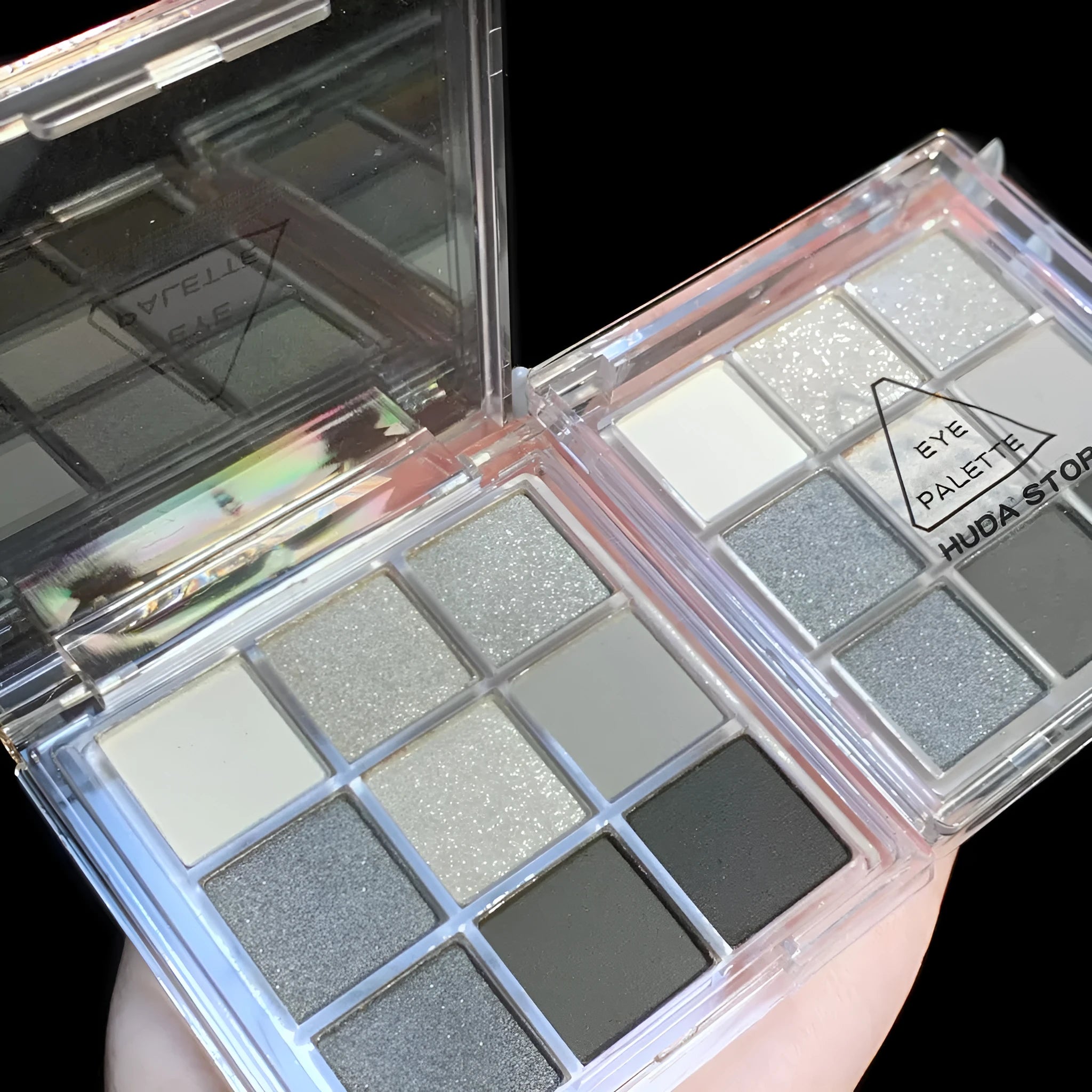 Open compact case showing nine powder eye shadow pans in neutral and smoky shades.