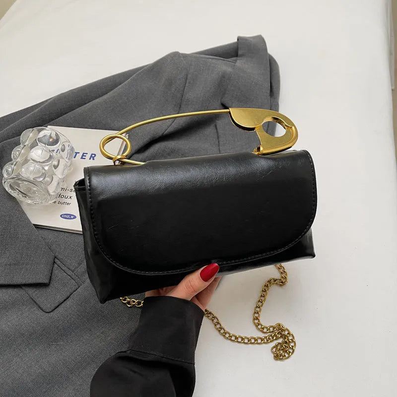Creative personality paper clip shoulder handbag in PU leather with sandwich pocket and file bag interior.