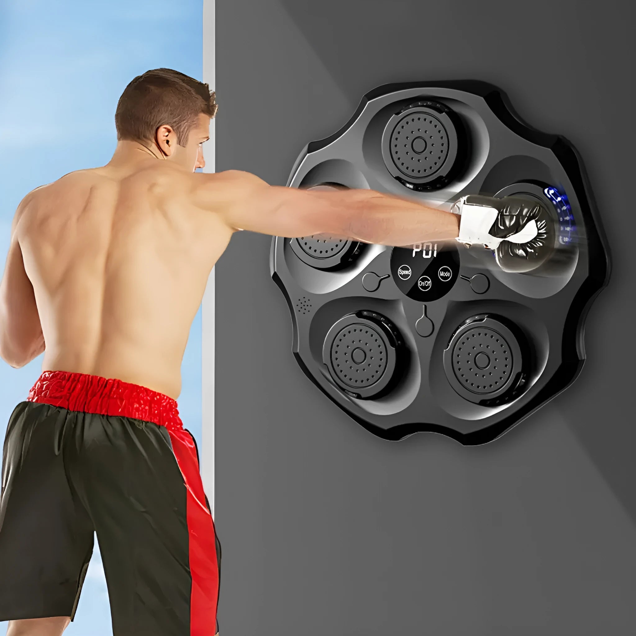 Black Bluetooth boxing wall target with glowing lights, mounted on a wall next to boxing gloves.