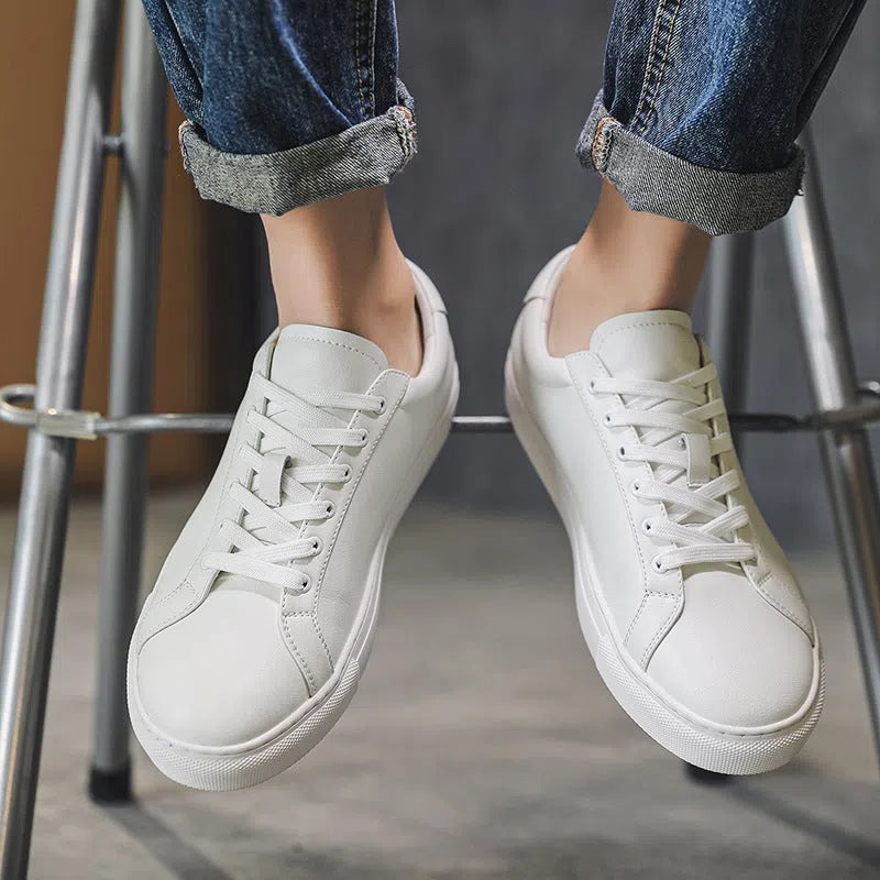 White flat-soled cowhide sneakers with stitching detail and round toe