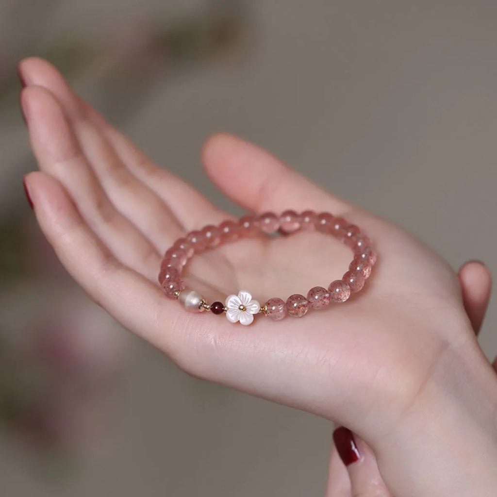 Light pink strawberry quartz crystal bracelet with peach blossom floral design and adjustable fastening