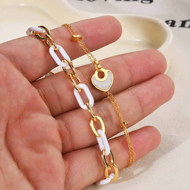 Women's adjustable stainless steel bracelet with a double-layered resin heart charm.