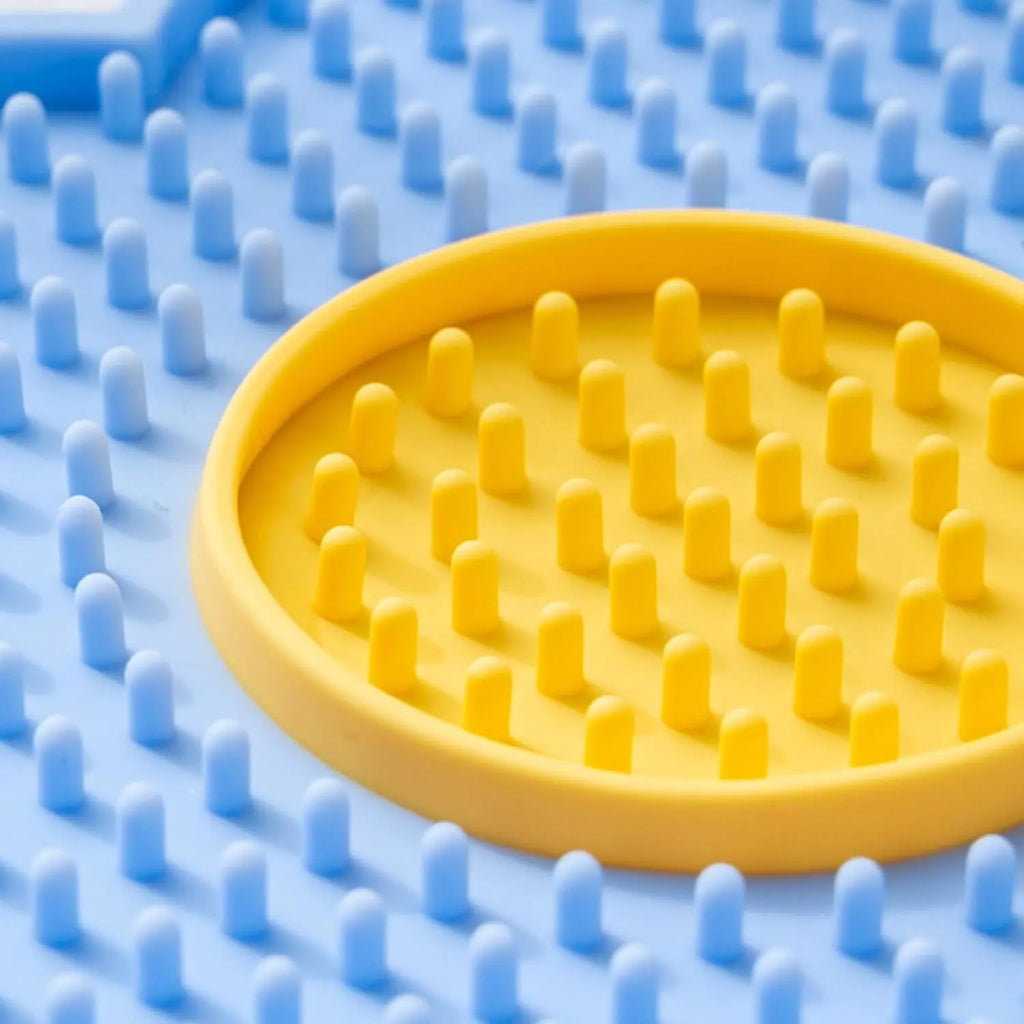 Flower-shaped silicone lick mat for dogs and cats with suction cups on a blue background.