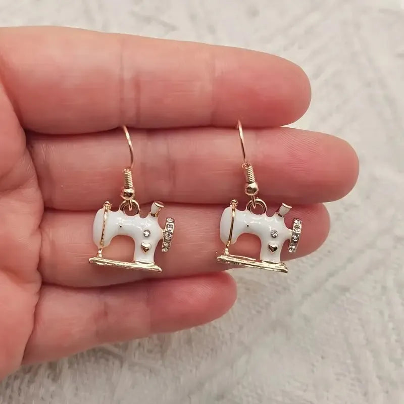 Vintage stereo sewing machine earrings in alloy with oil drip finish, shown in pink, black, white, and blue.