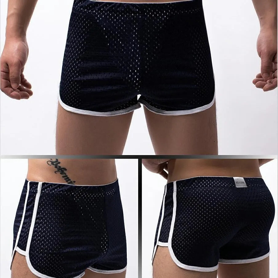 Men's grey three-point boxer shorts with a mid-rise waistband laid flat on a table.