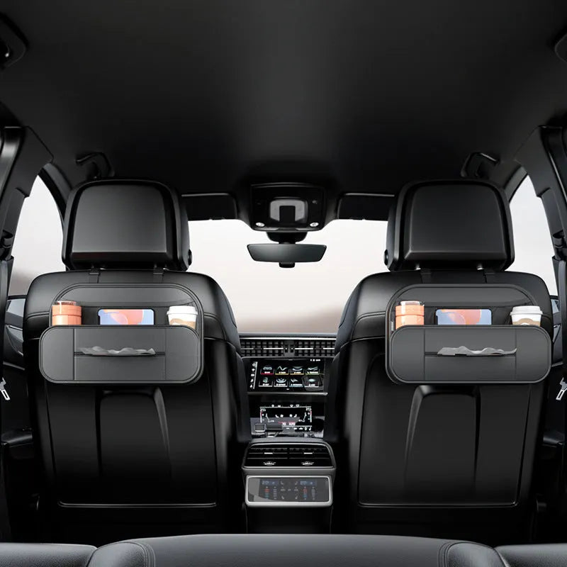 Black leather car seat rear storage bag with compartments, shown mounted on a car seat.