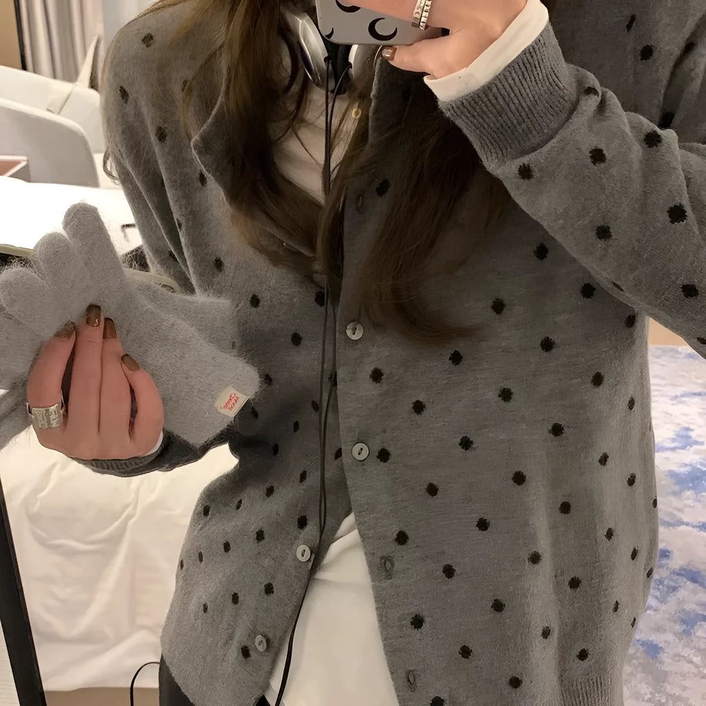 Women's grey dot knitted cardigan with crocheted flower detail on front, shown in loose fit.