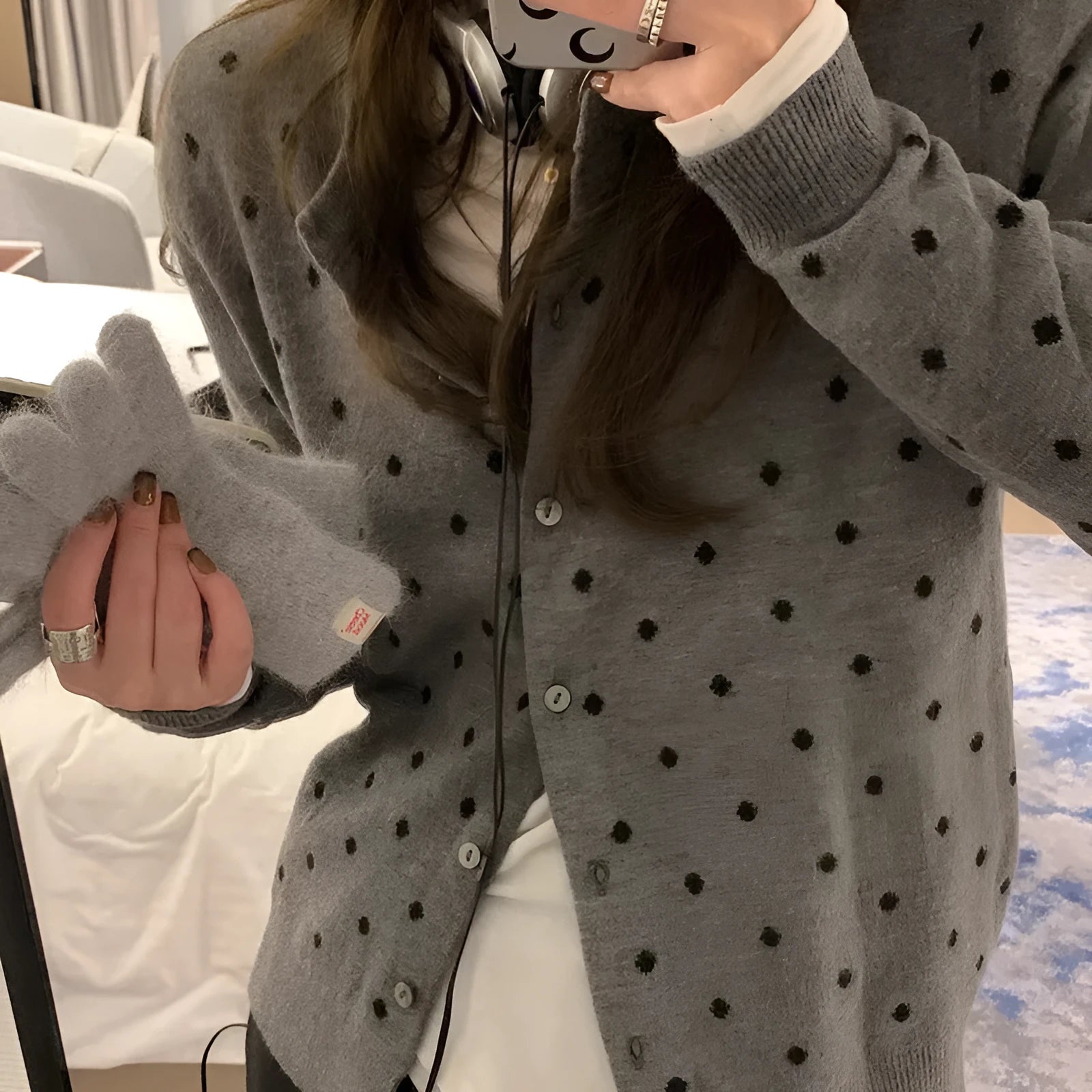 Women's grey dot knitted cardigan with crocheted flower detail on front, shown in loose fit.