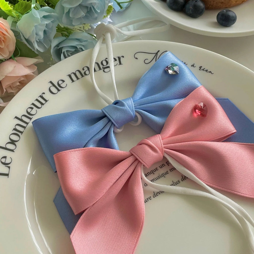 Blue and pink adjustable bow dog headdress hair band on a white background.