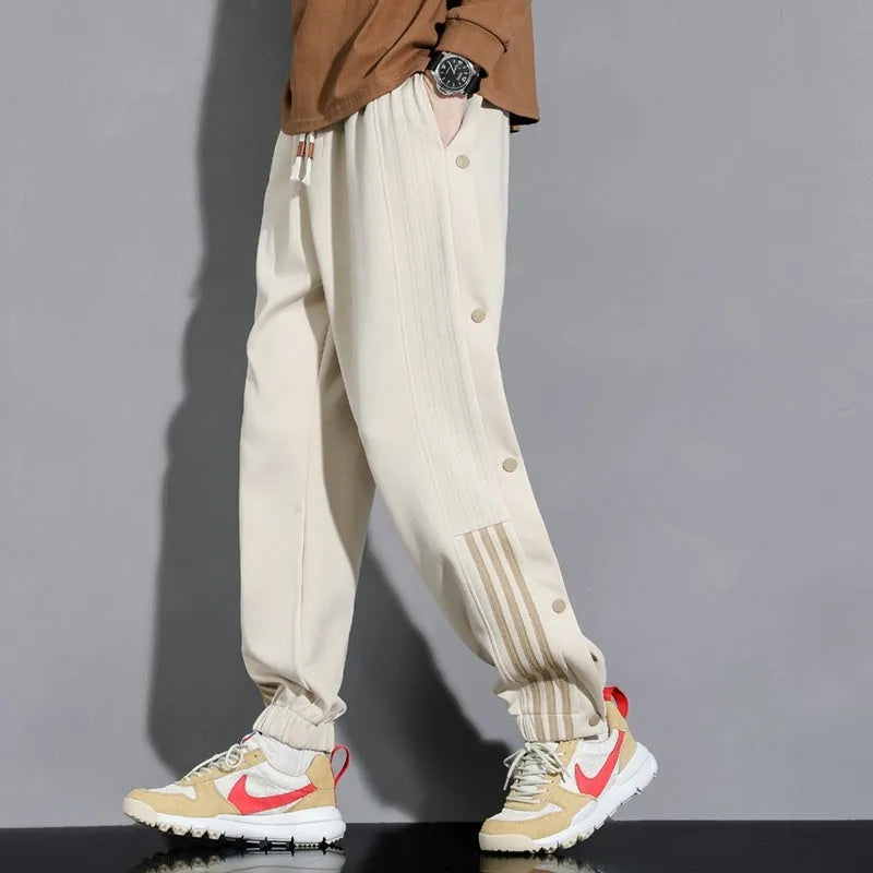 Men's black loose-fit ankle-tied sports trousers with high waist and drawstring closure on mannequin
