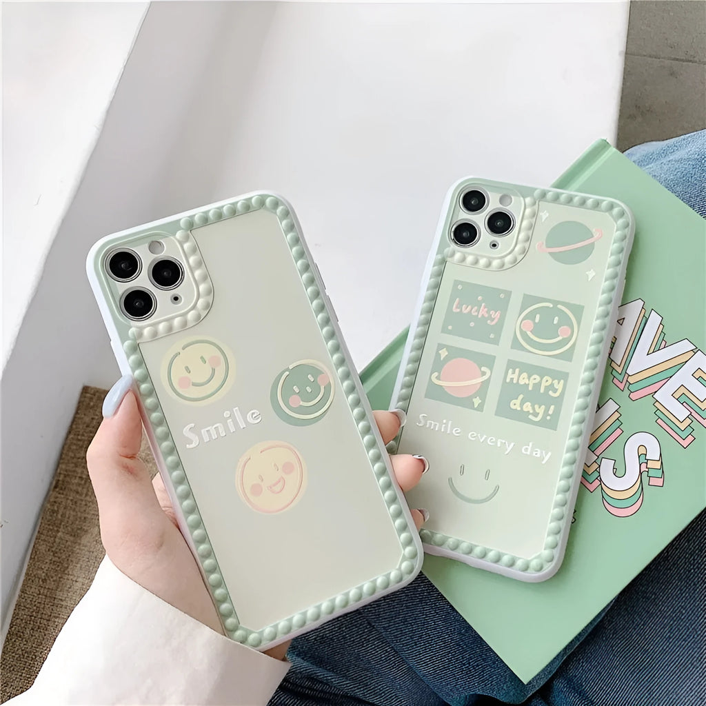 Green TPU iPhone case with geometric smiley face design and polka dot frame.