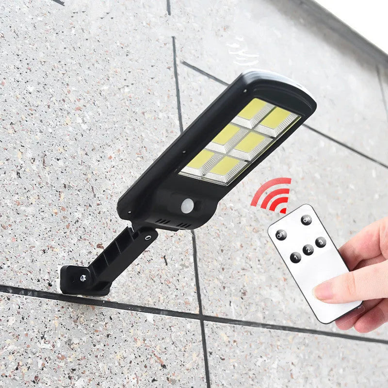 Black solar-powered outdoor motion sensor light with solar panel