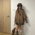 A women's plush triangle shawl cape with tassel trim, shown in a cashmere-acrylic blend fabric.