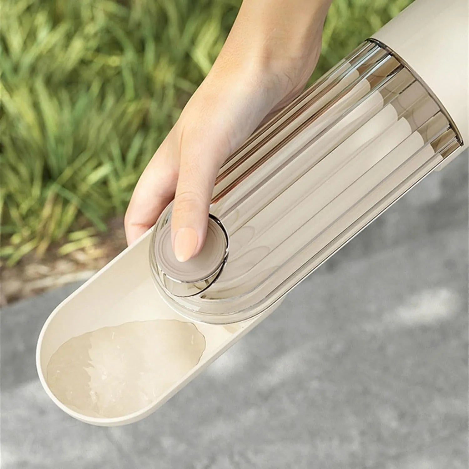 Beige and green foldable dog water bottle with food container, showing scale next to a dog's muzzle.