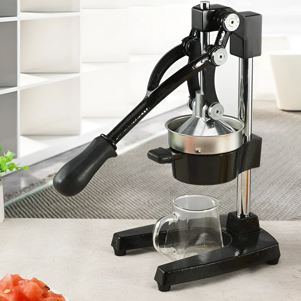 Black ductile cast iron manual citrus juicer with stainless steel strainer on a kitchen counter