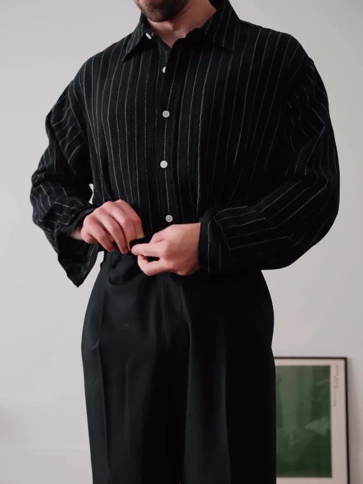 Men's black pinstriped polyester button-down shirt laid flat, showing regular fit and striped pattern.