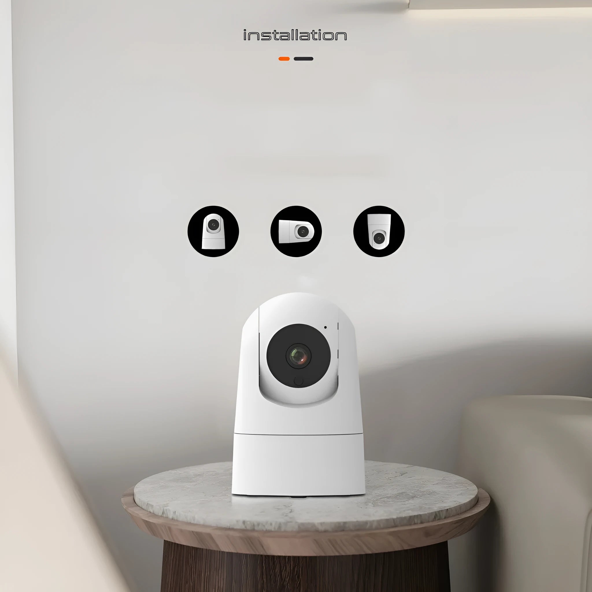 White indoor security camera with wide-angle lens on a table, showing power cable and mounting bracket.