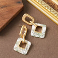 A pair of hollow geometric square copper earrings with chamfered corners on a white background.