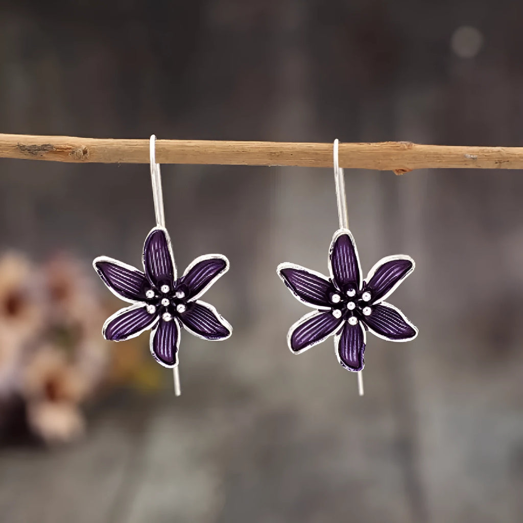 Close-up of a pair of purple alloy flower-shaped earrings with a retro elegant style.