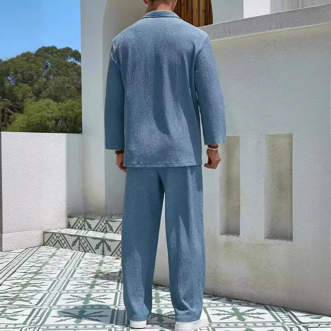 Man wearing a casual lake blue polyester shirt and matching trousers from a two-piece suit set.