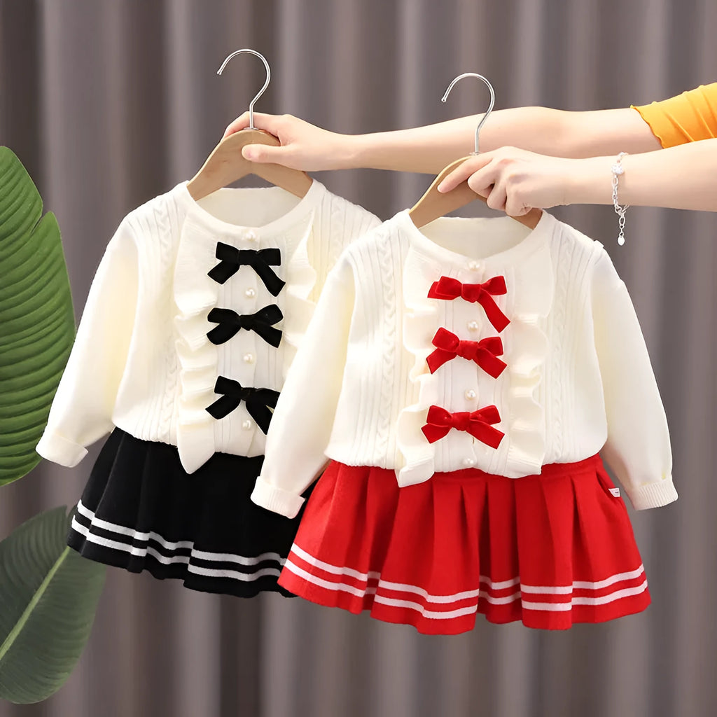 Knitted baby girl two-piece skirt suit in pink with bow detail and long sleeves, autumn wear