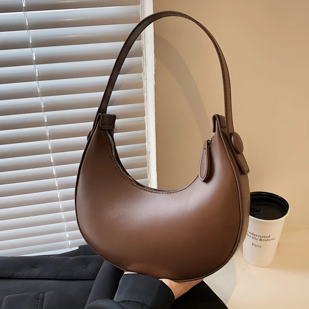 Retro-style dumpling-shaped PU leather shoulder bag in cream yellow showing front sandwich pocket.