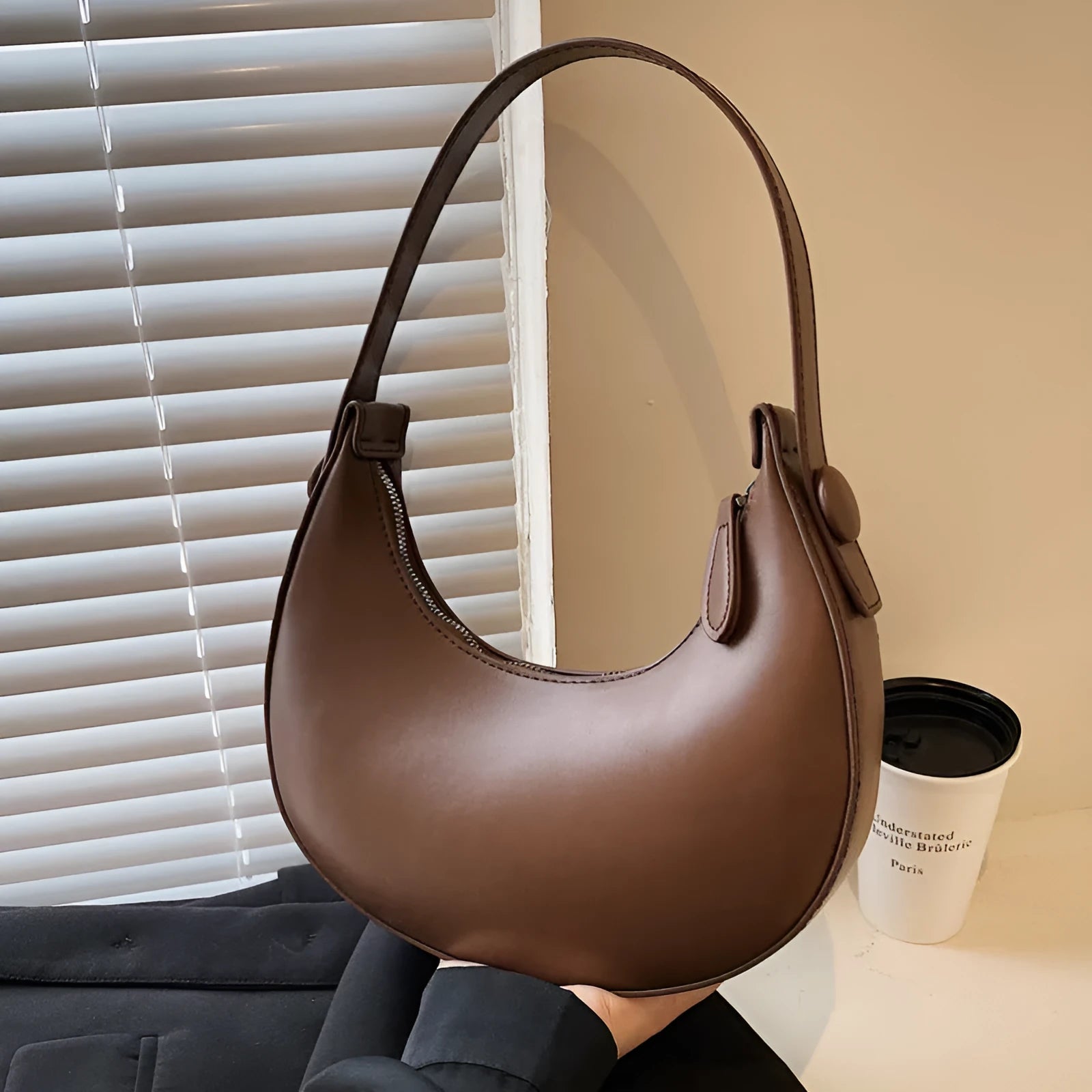 Retro-style dumpling-shaped PU leather shoulder bag in cream yellow showing front sandwich pocket.