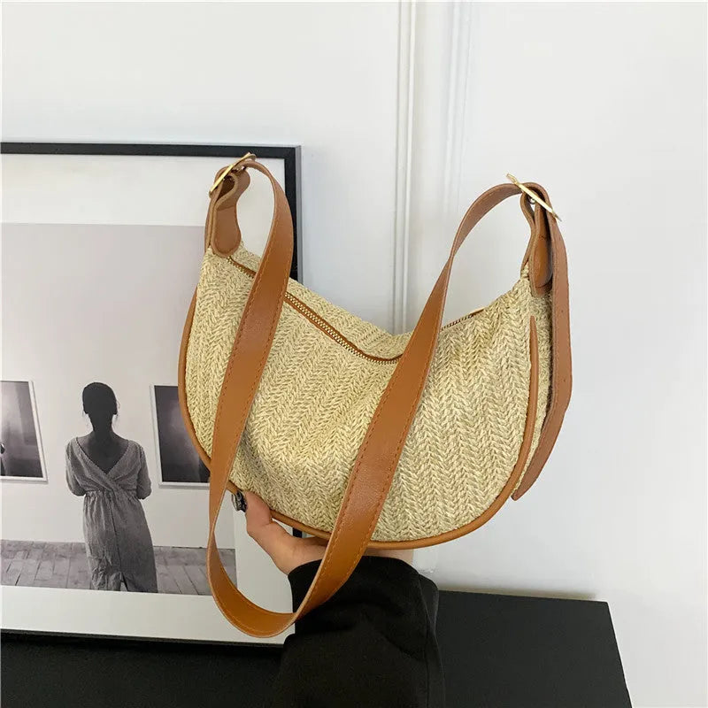 Women's straw woven crossbody bag showing knitted texture and single shoulder strap, shown in corrugated black colour.