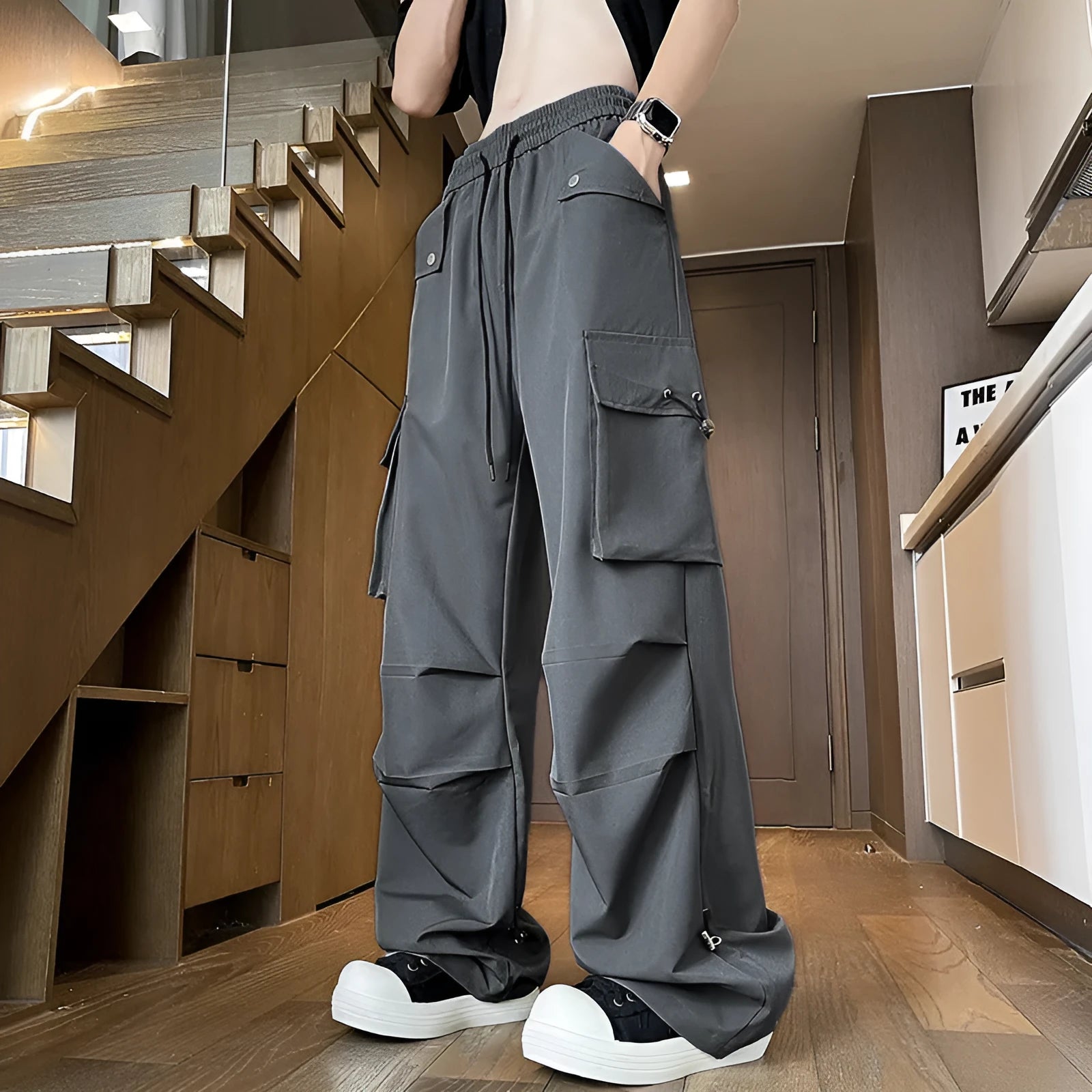 Black waterproof plus size loose straight-leg trousers with a drawstring waist on a hanger.