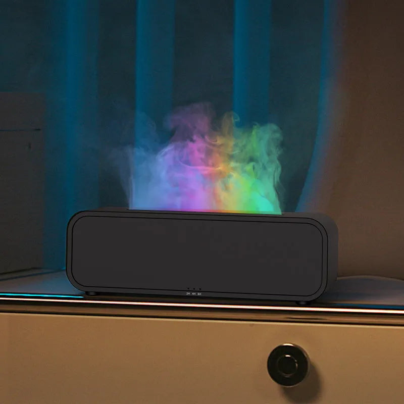 Black and white USB essential oil aromatherapy diffuser with colour-changing lights and remote control on a table
