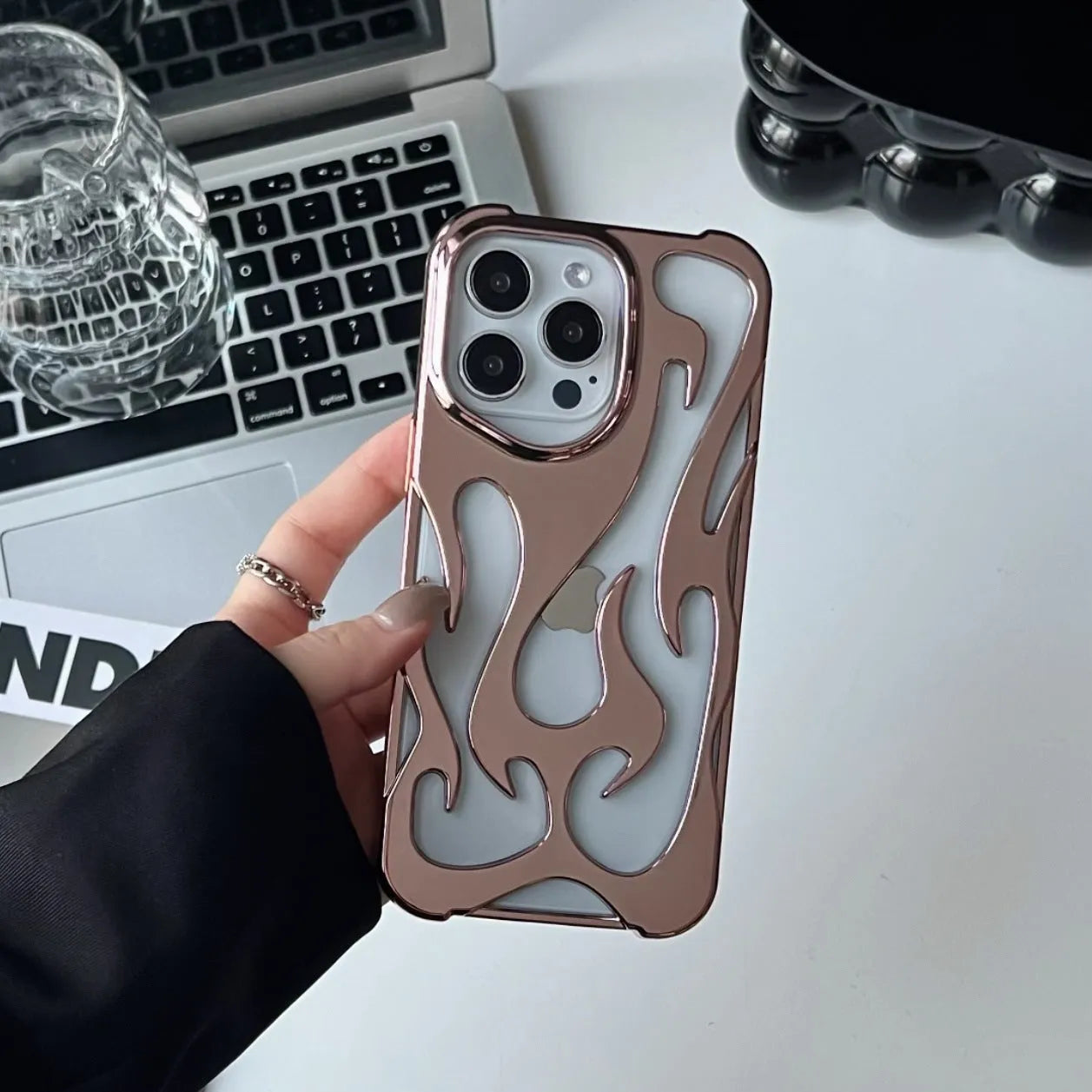 Electroplated hollow flame pattern phone case for iPhone, showing silver finish and perforated design for heat dissipation.