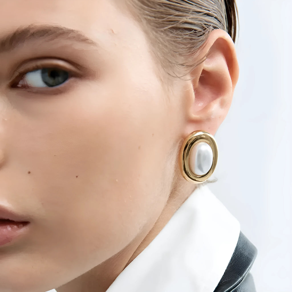 A pair of stainless steel vintage pearl stud earrings for women with a post-back closure.