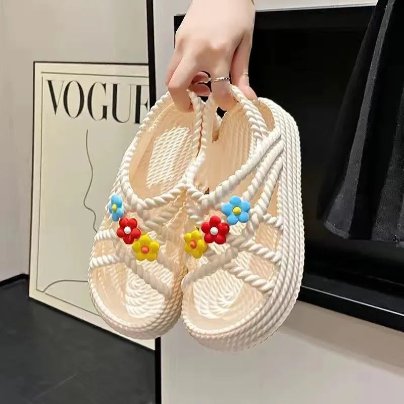 Women's PVC sandals with flower decorations in beige and black colours showing round-toe non-slip design