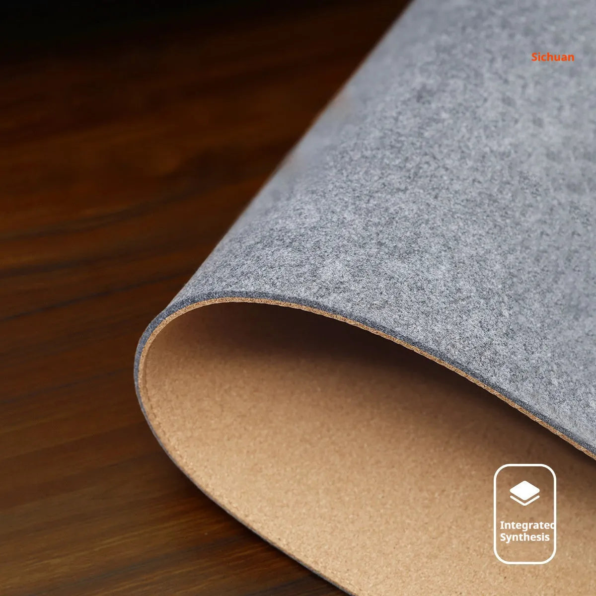 Oversized felt cork desk mat in black and grey pattern on a wooden desk
