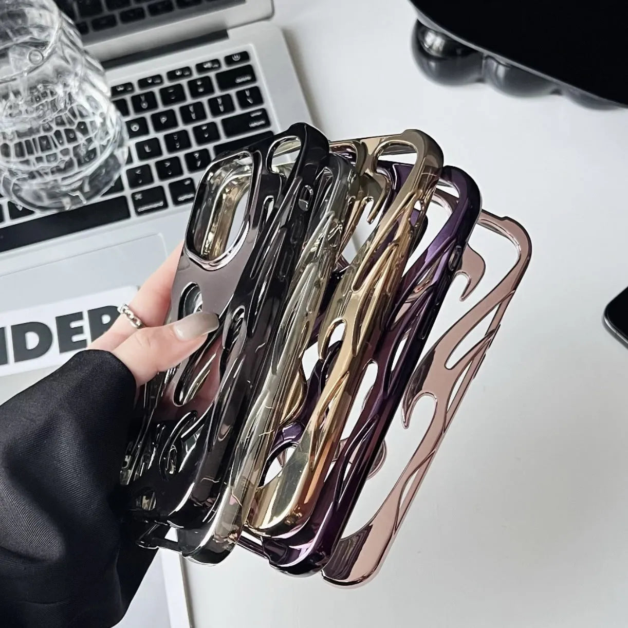 Electroplated hollow flame pattern phone case for iPhone, showing silver finish and perforated design for heat dissipation.