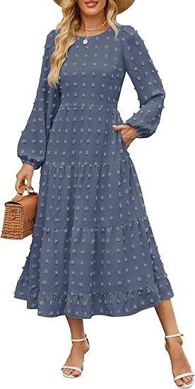 A woman wearing a beige high waist long sleeve dress with ruffled sleeves, a round neck, and a solid colour design.