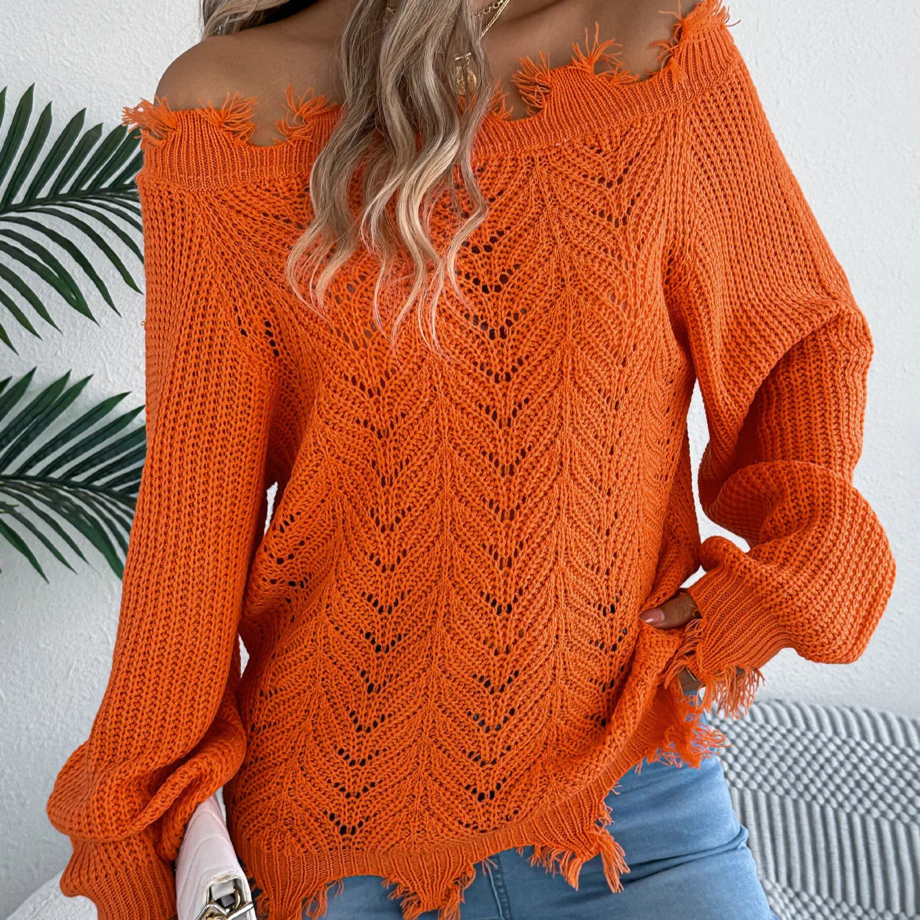 Women's white cut-off-the-shoulder long sleeve pullover sweater with hollow-out detail on front.